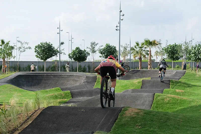 Cyclist riding along the Meydan Cycle Track in Dubai, with a smooth path and scenic surroundings under a clear sky.