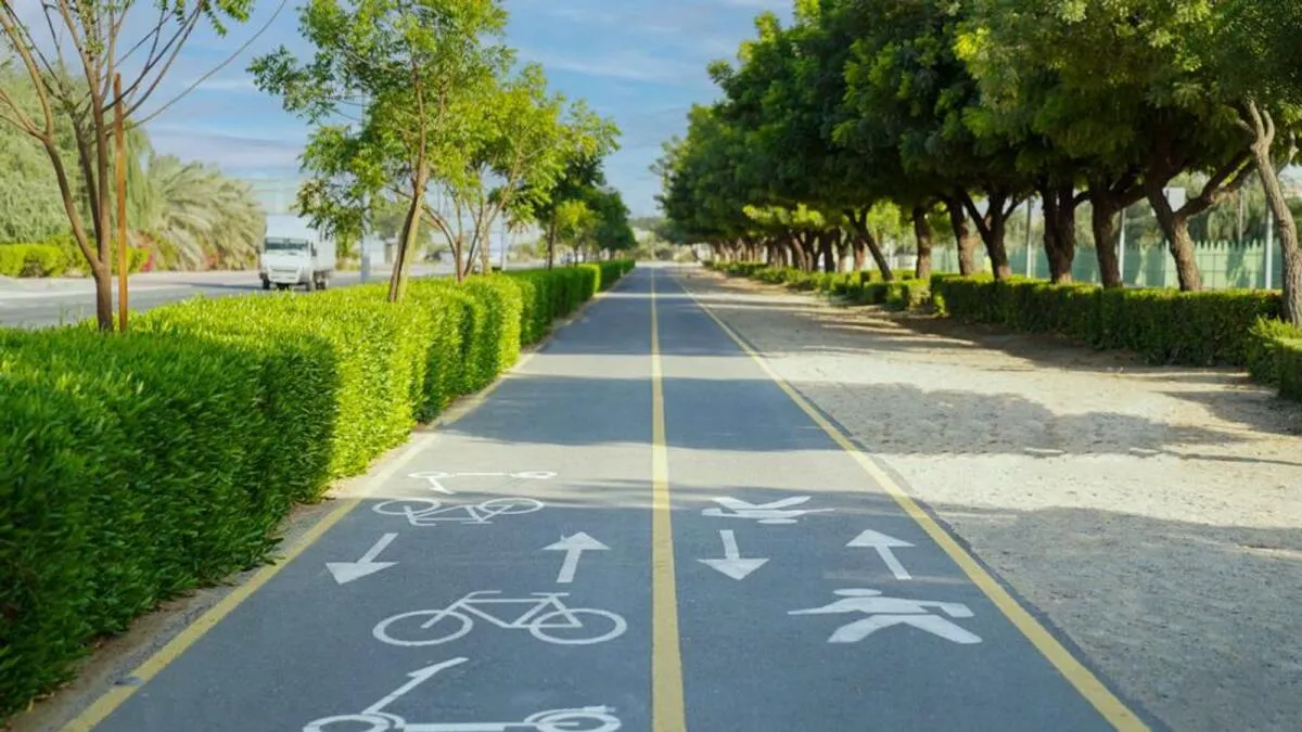 Cyclist riding along the Meydan Cycle Track in Dubai, with a smooth path and scenic surroundings under a clear sky.