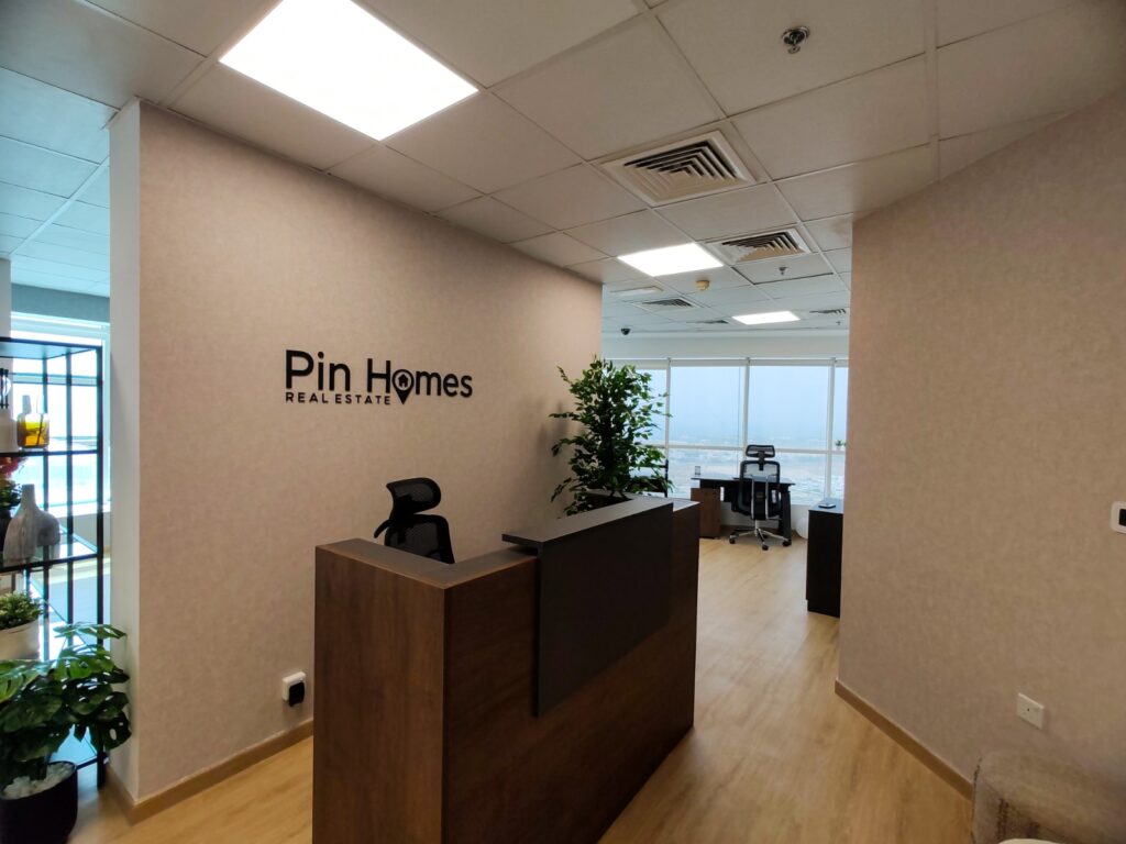 Interior of Pin Homes Real Estate LLC office in Barsha Heights, Dubai showing modern workspace and client area